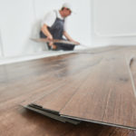 Worker,Laying,Vinyl,Floor,Covering,At,Home,Renovation